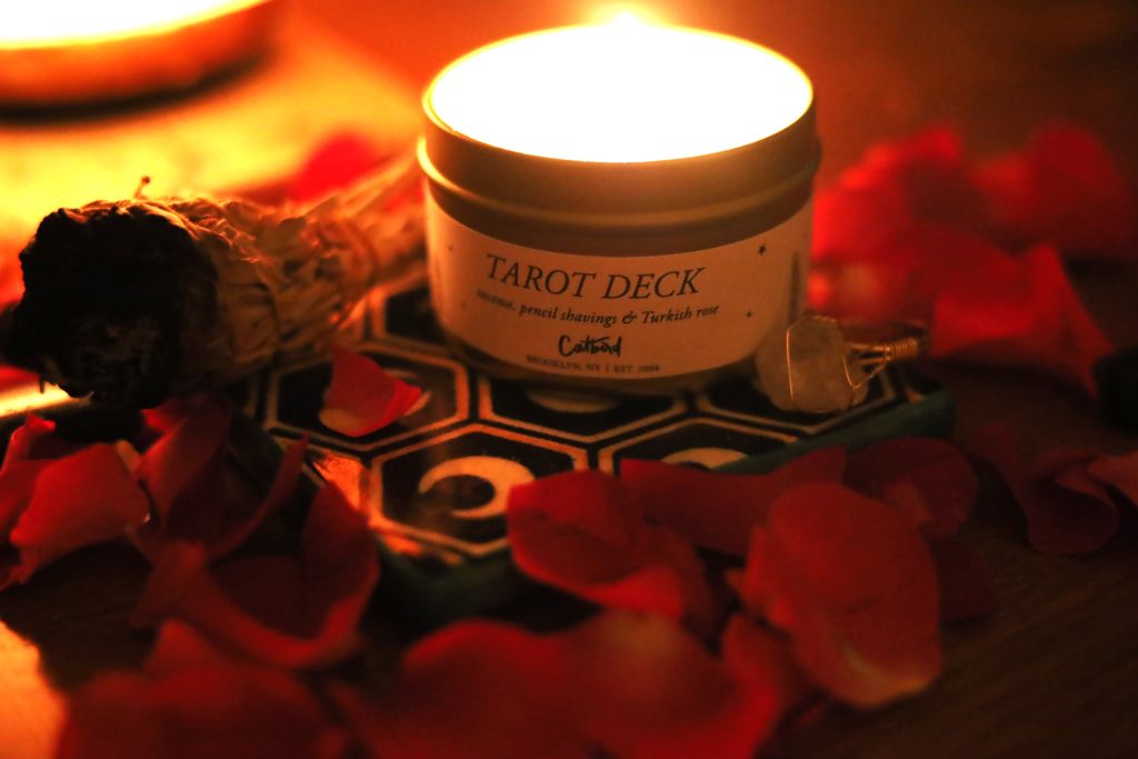 tarot deck candle with sage and rose petals 
