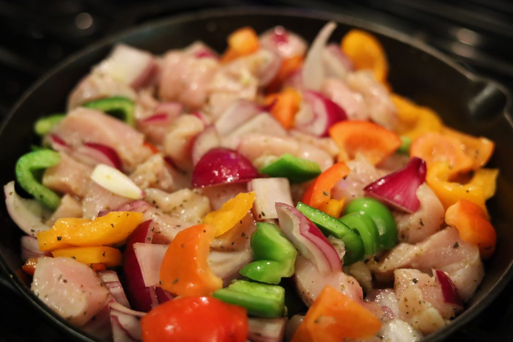 chicken and veggies cooking in pan