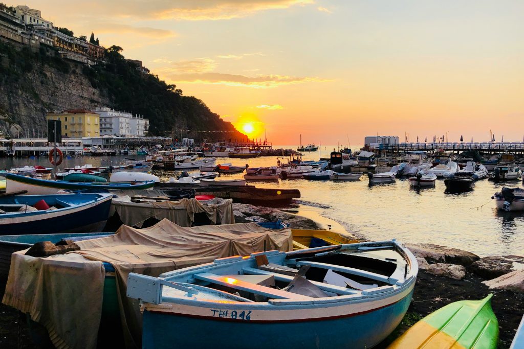small boats docked at sunset along beach of Sorrento, Italy