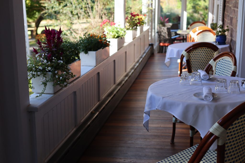 view of porch and elegant bistro tables outside 