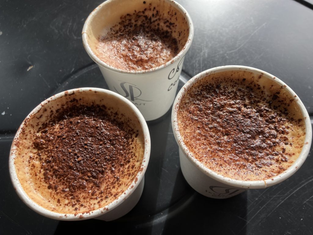 three cups of cappucino on a table 