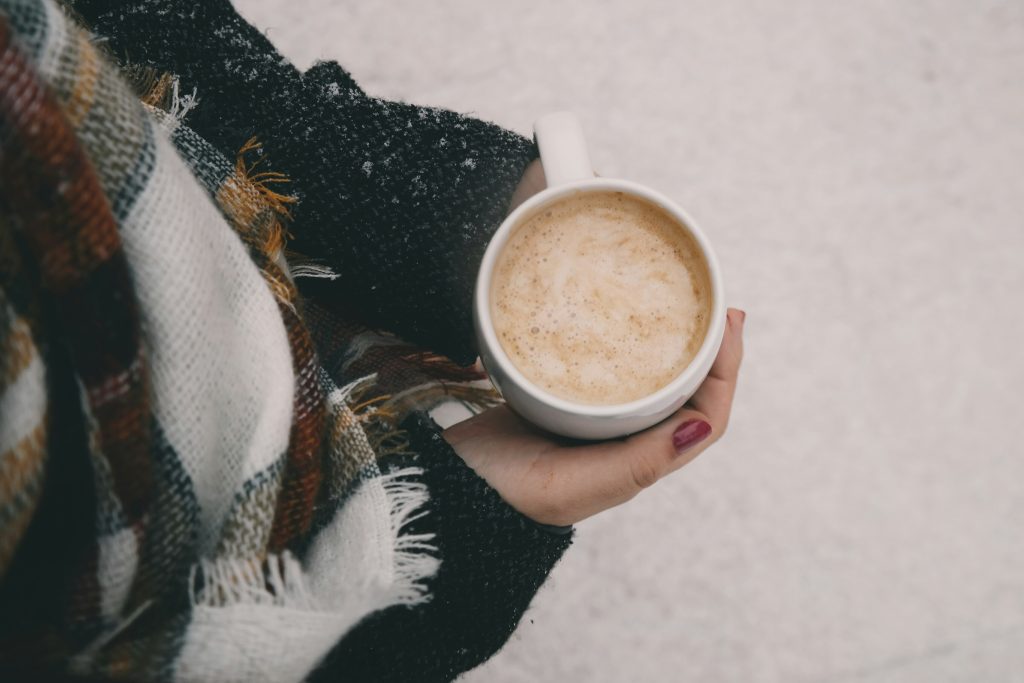 woman holding hot cocoa in winter