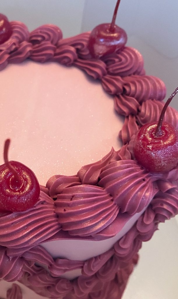 vintage birthday cake with cherries and edible glitter in pinks and purples 